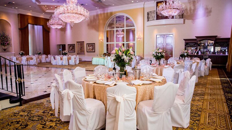 Ballroom. Seven tables. Gold table clothes. White chair covers. White napkins.