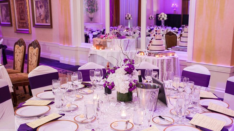 Banquet table setting. White table cloth. Purple napkins. Purple seat coverings.